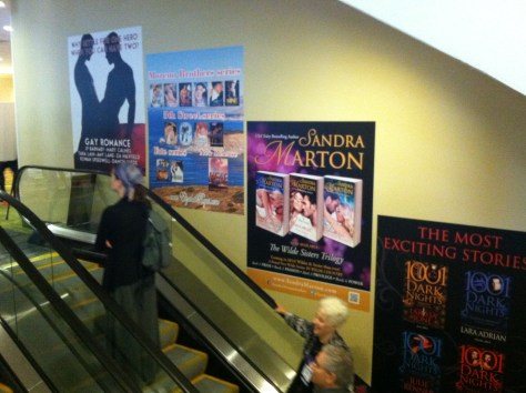 Wall-size posters over escalators, including m/m clinch cover.