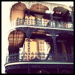 Corner of building in New Orleans with elaborate ironwork balconies, a photo I took in the French Quarter.